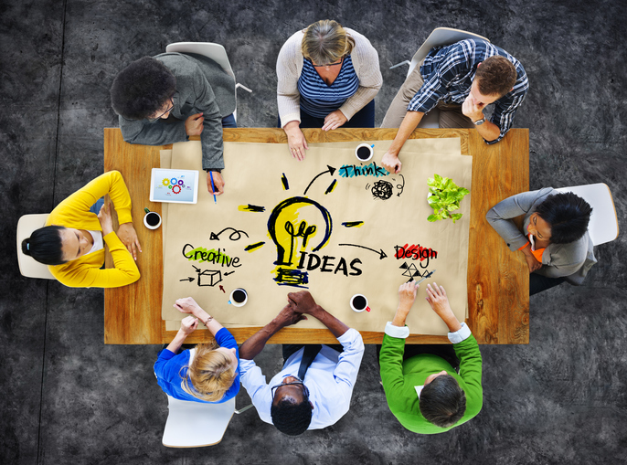 Looking down at group of people around desk, IDEAS. 